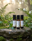 Three bottles of essential oils on a stone in a forest setting